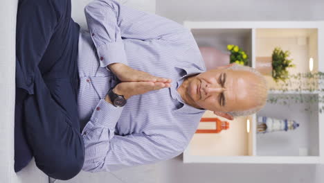 Vertical-video-of-Old-man-meditating-at-home.